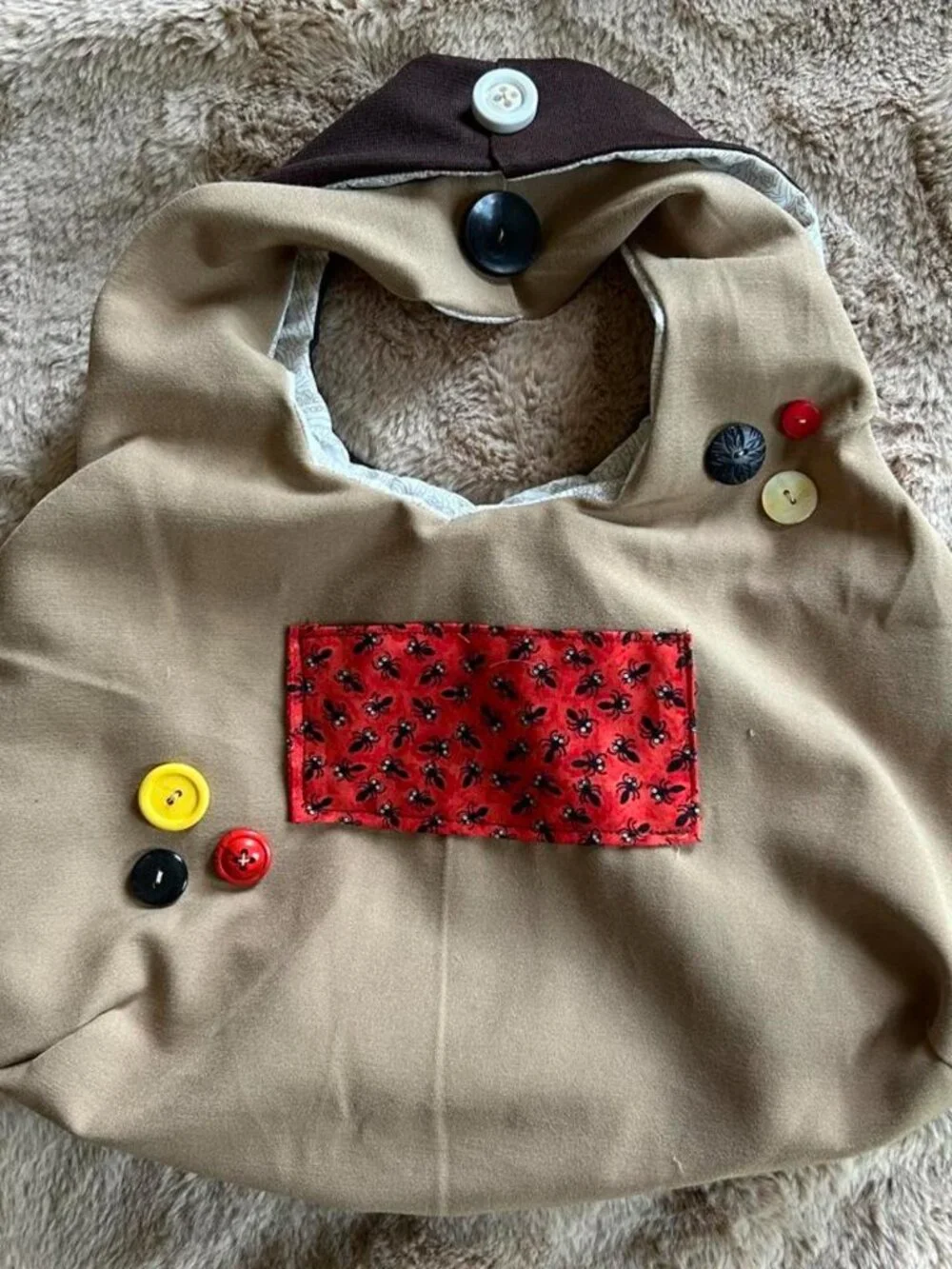 Brown & tan hobo bag with red ant pattern front pocket and hand sewn buttons